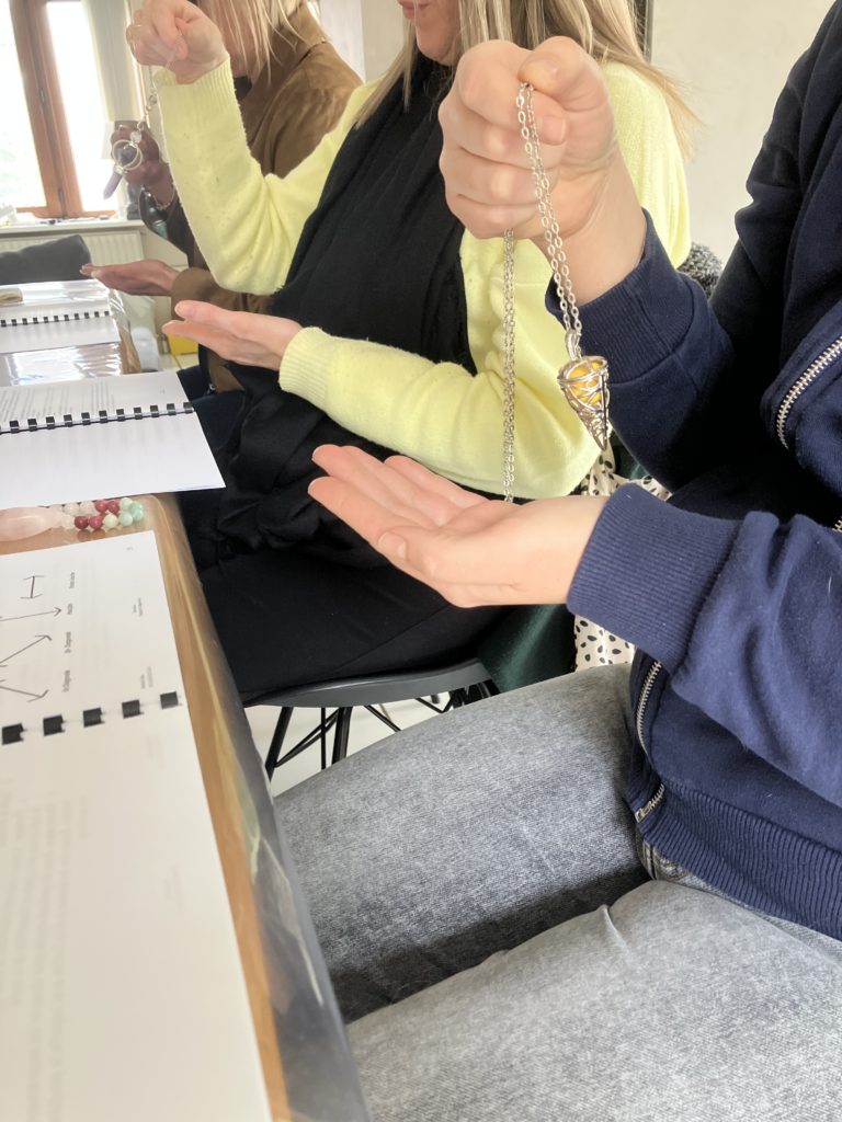 Élève découvrant le pendule lors d'une formation en énergétique près de Bruxelles